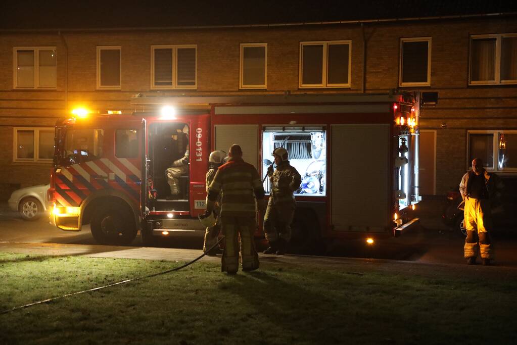 Hout en afval in brand tegen gevel