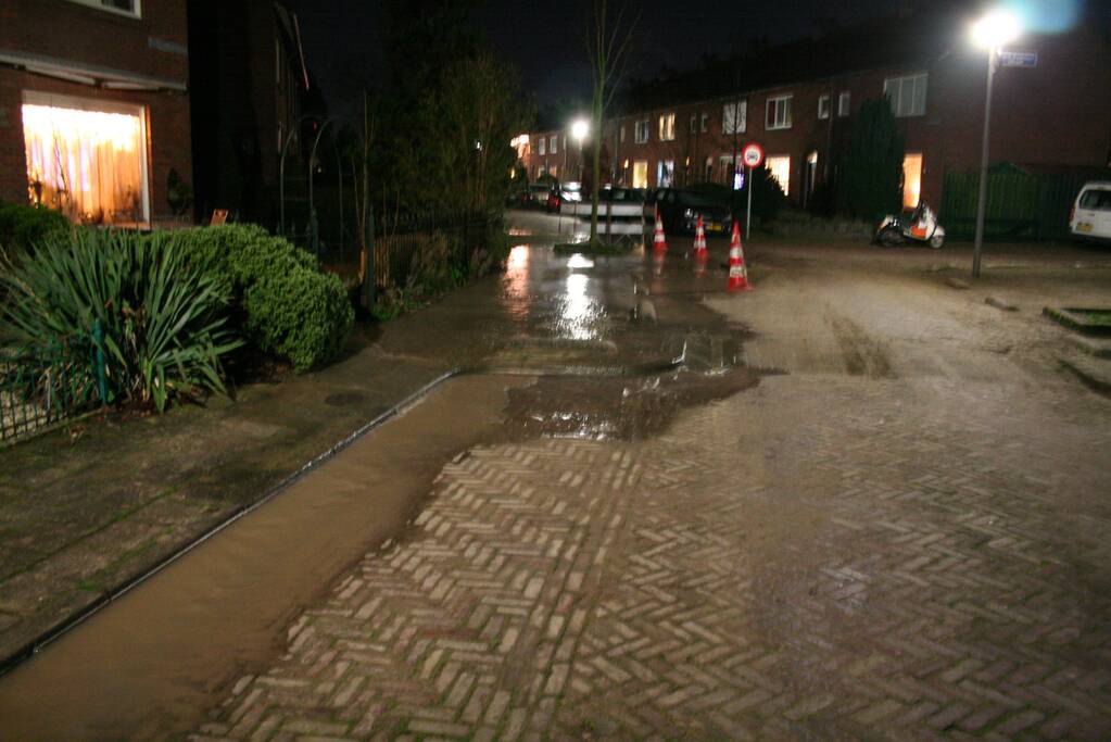 Straat onder water door gesprongen waterleiding