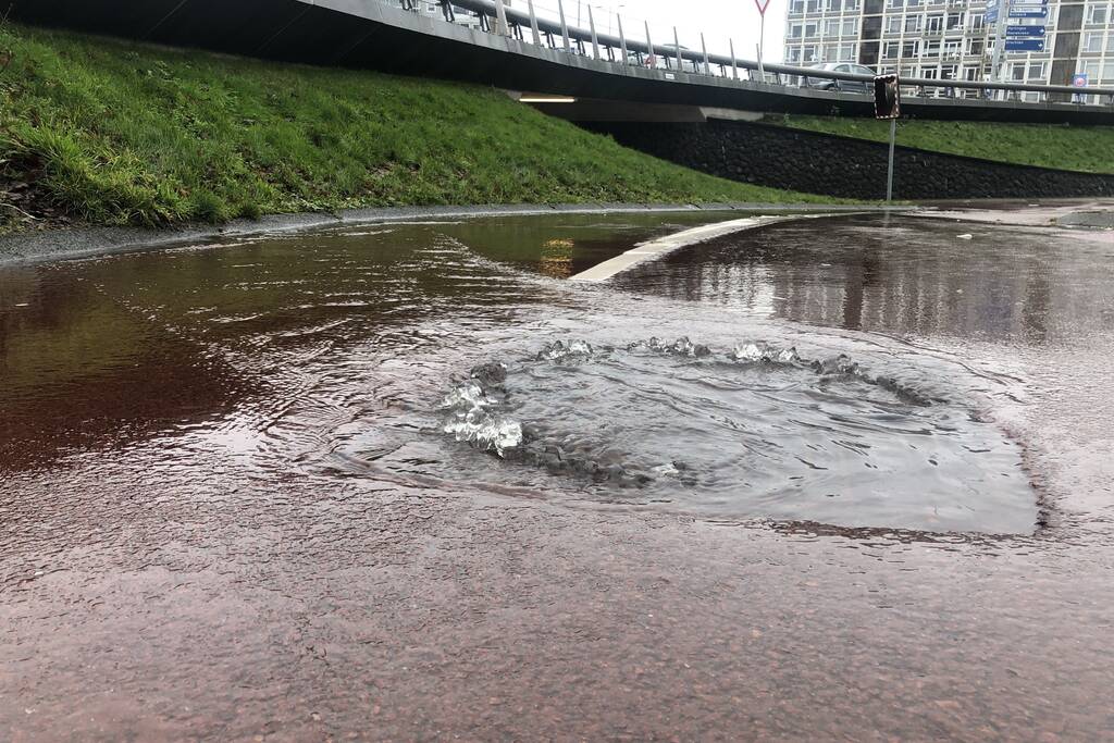 Water spuit uit putdeksel