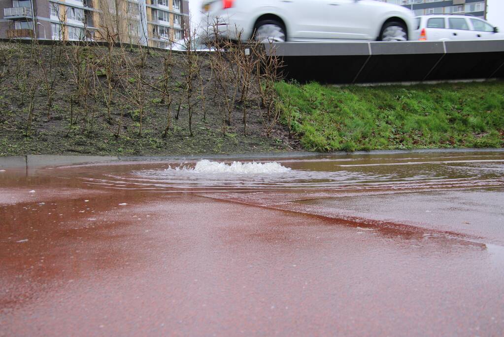 Water spuit uit putdeksel