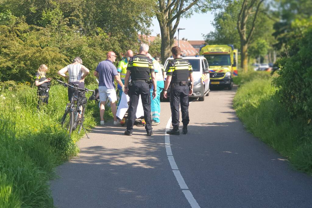 Vrouw gaat met fiets onderuit