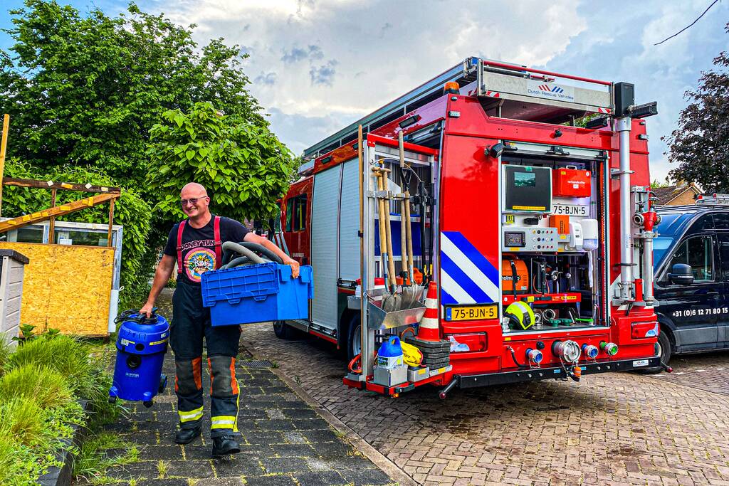 Brandweer helpt met leegpompen van onderwater gelopen woning