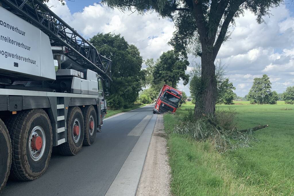 Vrachtwagen met oplegger komt vast te zitten in greppel