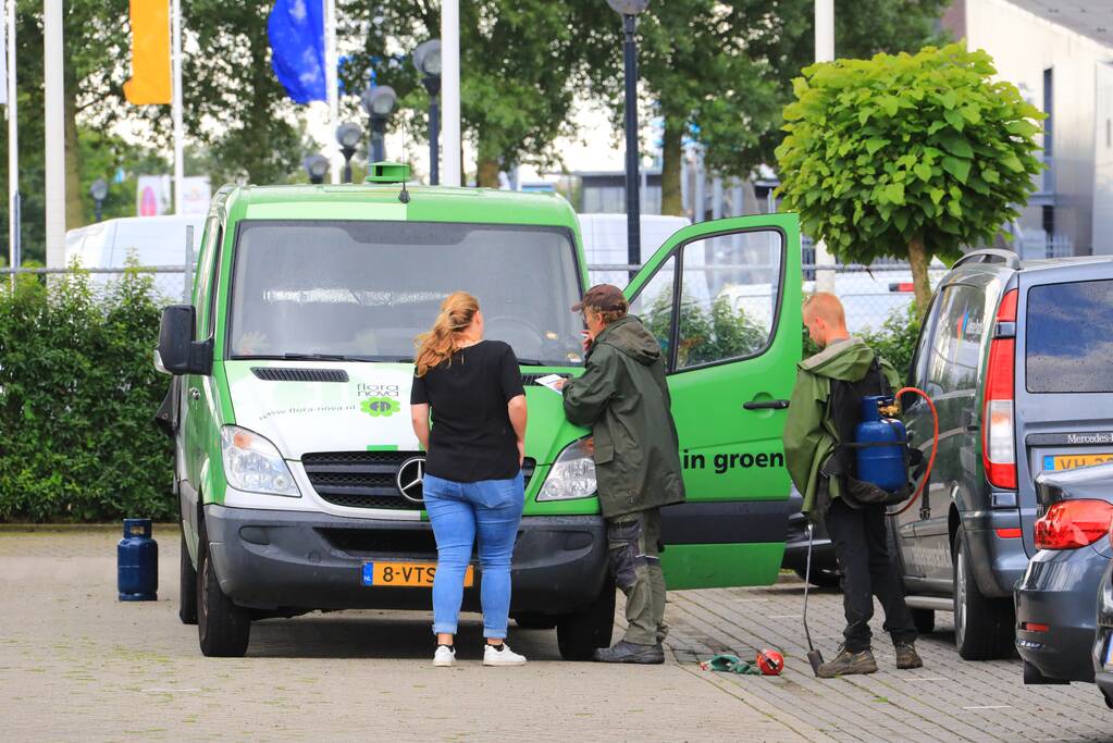 Vlammen onkruidbrander slaat over naar geparkeerde bestelbus