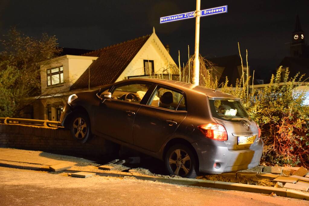 Auto belandt op betonnen muur van de brug