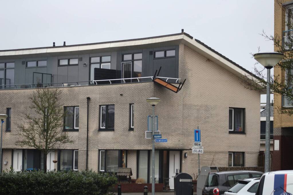 Weggewaaide tafel hangt gevaarlijk over balkonrand