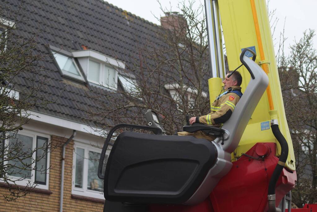 Brandweer zet loszittende dakpannen vast