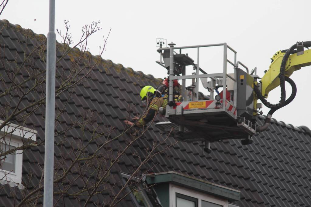 Brandweer zet loszittende dakpannen vast