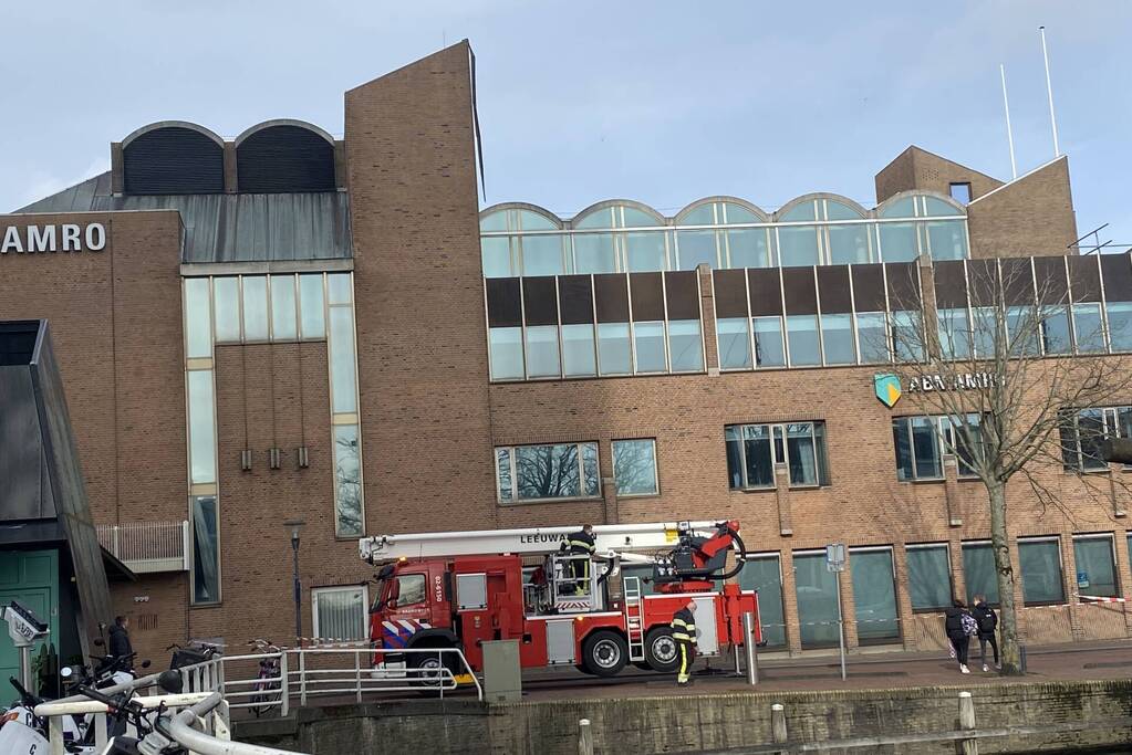 Brandweer verwijderd losgekomen dakbedekking