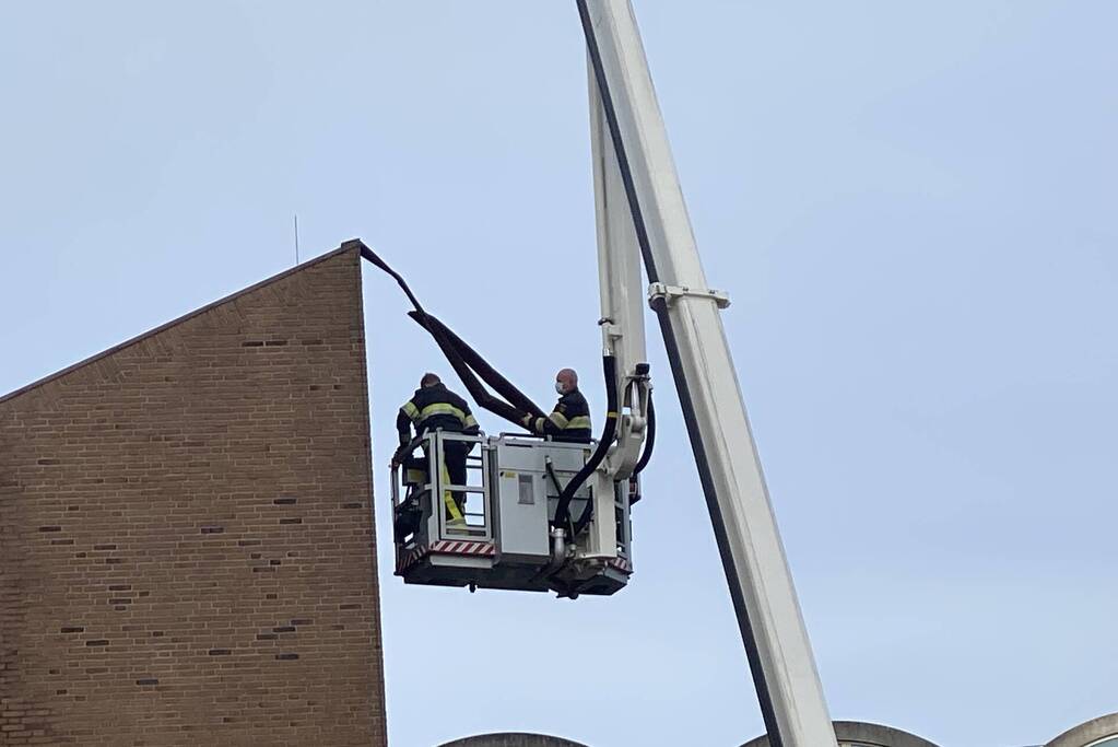 Brandweer verwijderd losgekomen dakbedekking