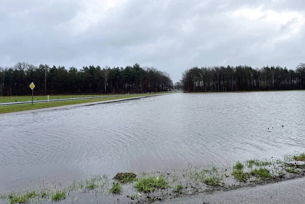 Wegdek en fietspad onder water door hevige regenval