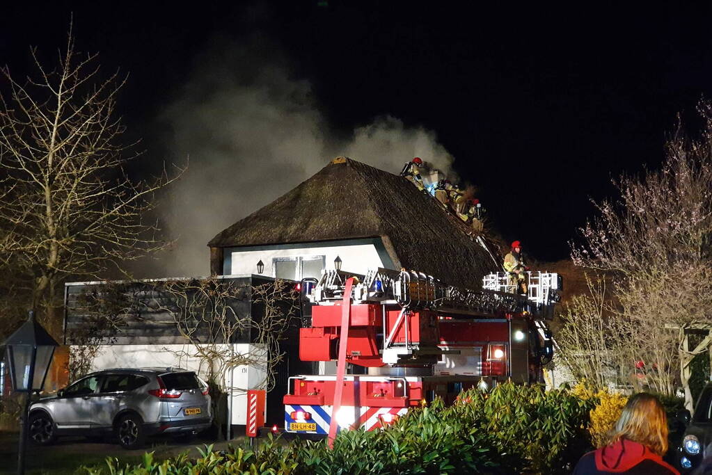 Brand in dak van villa met rietendak