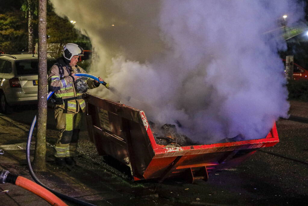 Vonken en rookontwikkeling bij brand in bouwafval container