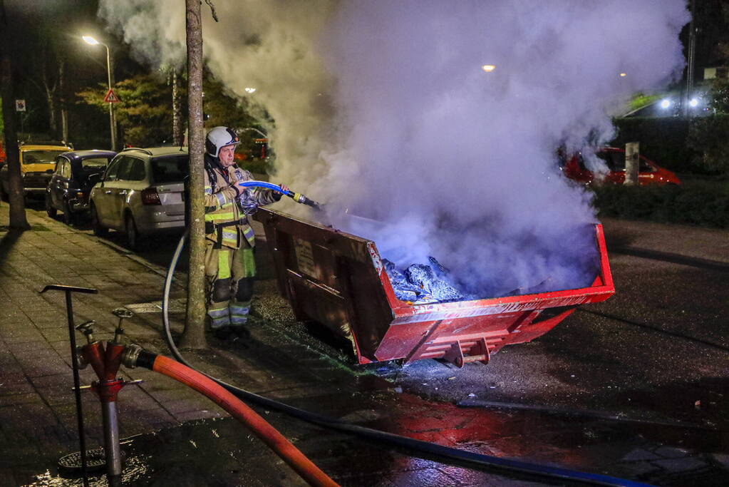 Vonken en rookontwikkeling bij brand in bouwafval container