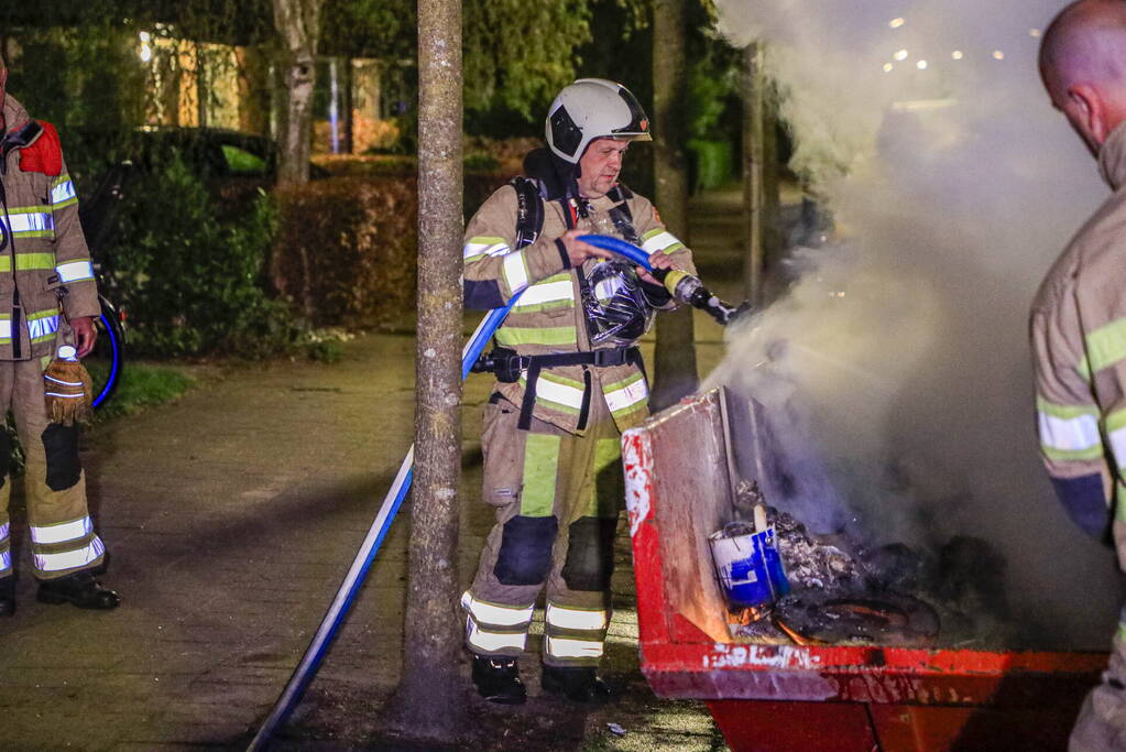 Vonken en rookontwikkeling bij brand in bouwafval container