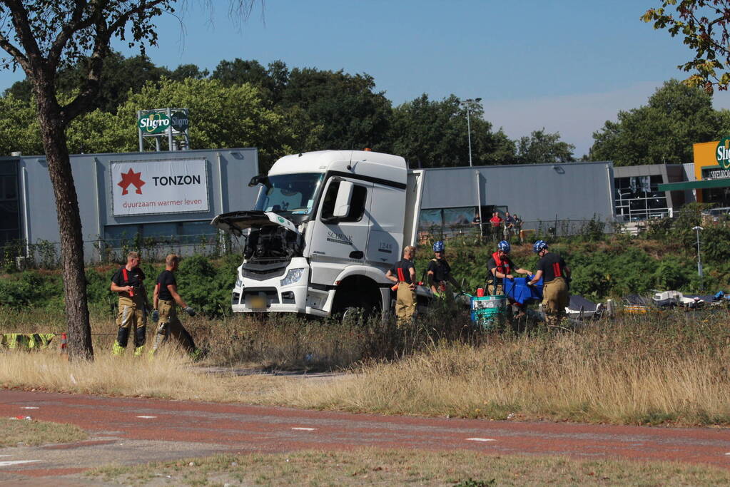 Vrachtwagen hangt gevaarlijk over de waterkant