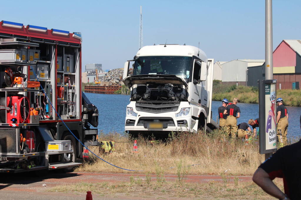 Vrachtwagen hangt gevaarlijk over de waterkant