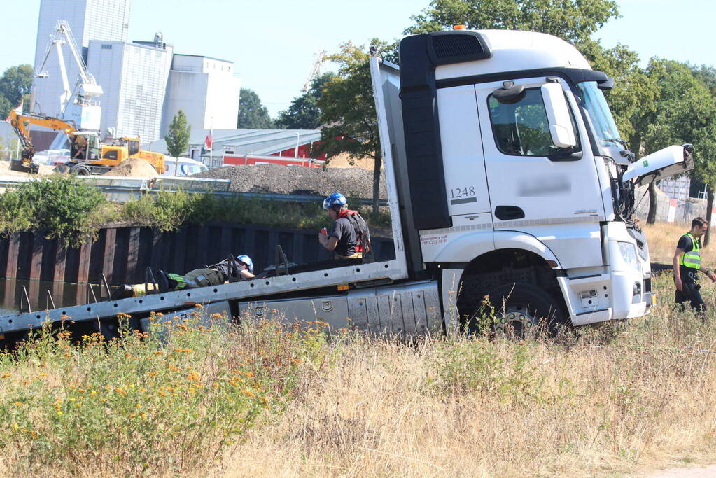 Vrachtwagen hangt gevaarlijk over de waterkant