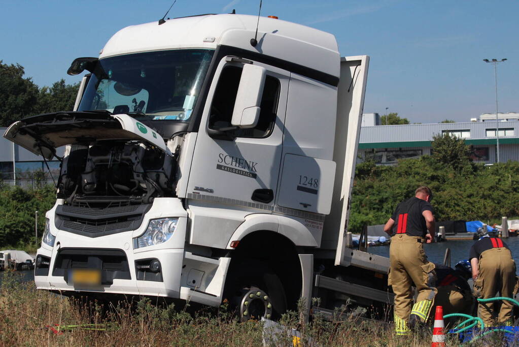 Vrachtwagen hangt gevaarlijk over de waterkant