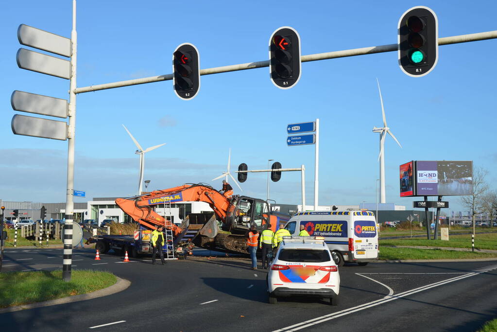 Graafmachine valt van dieplader