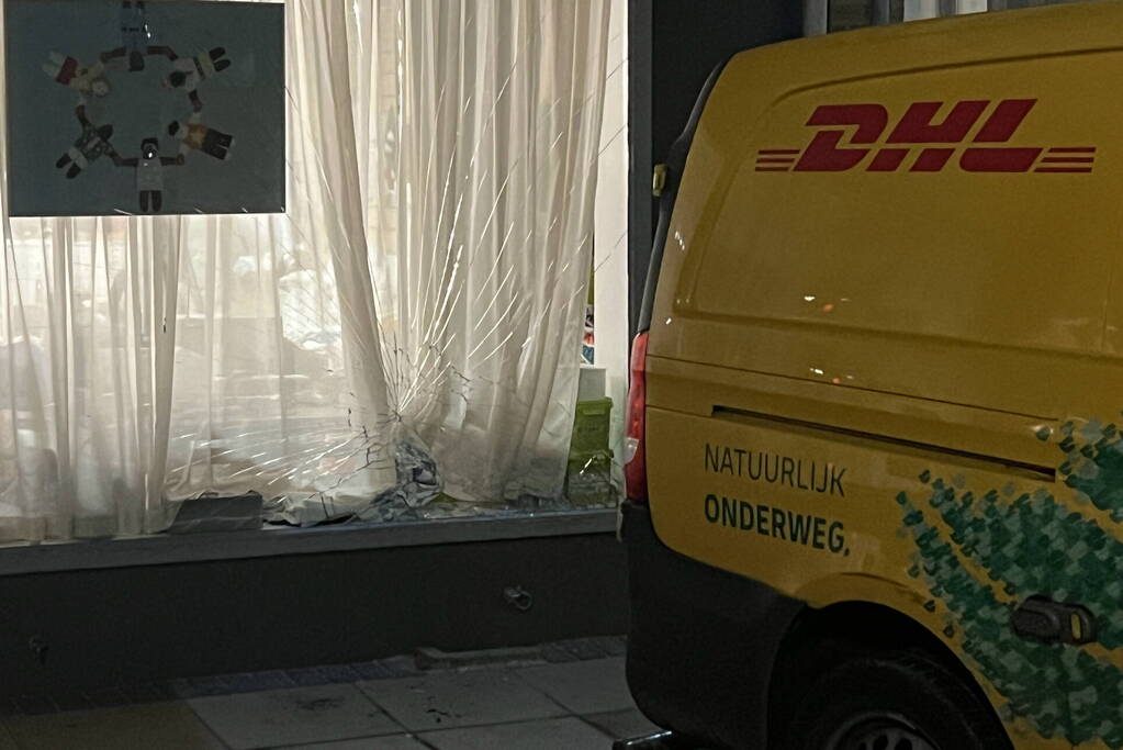 DHL bezorger ramt gevel na achteruit rijden