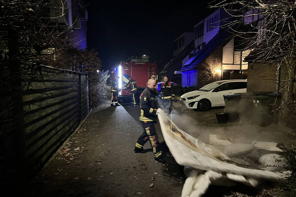 Brandende deken geblust met emmer water