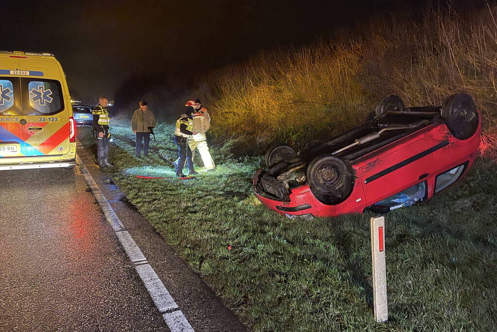 Auto belandt op de kop naast weg