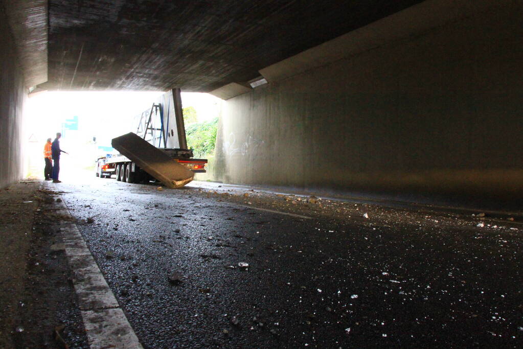 Vrachtwagenchauffeur rijdt met lading tegen spoorviaduct