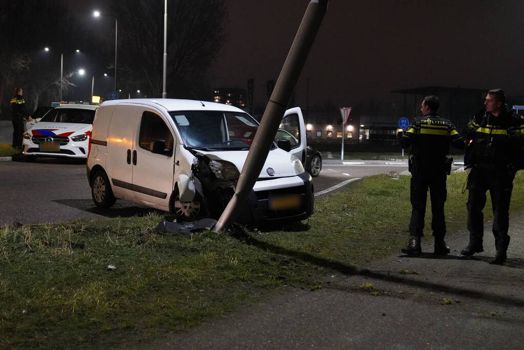 Bestelwagen klapt op lantaarnpaal