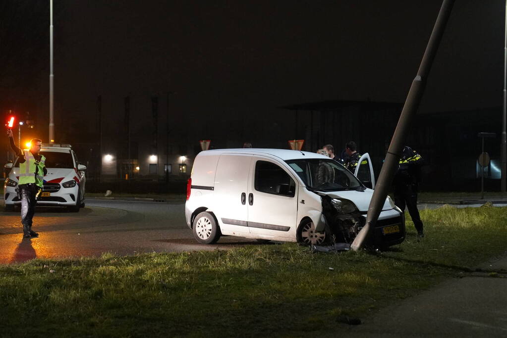 Bestelwagen klapt op lantaarnpaal