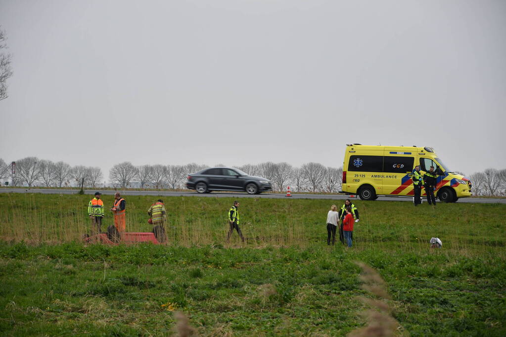 Auto belandt op zijn kop naast snelweg