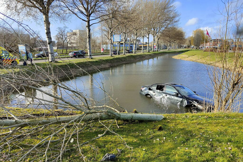 Automobilist vliegt uit bocht, ramt boom en belandt in water