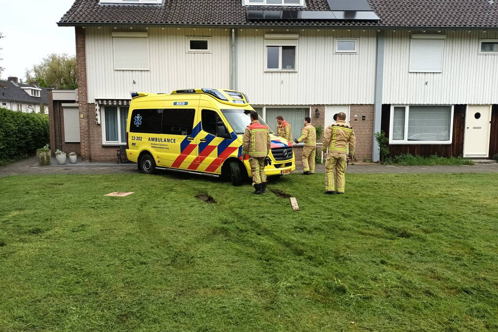 Ambulance rijdt zich vast op grasveld voor woning