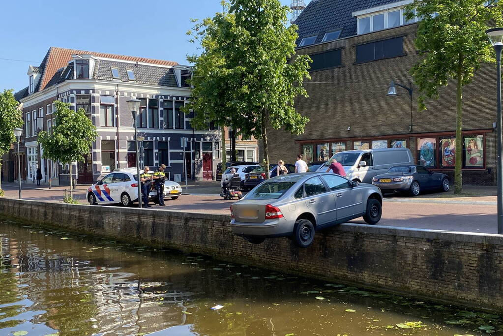 Auto blijft op randje van kade hangen boven gracht