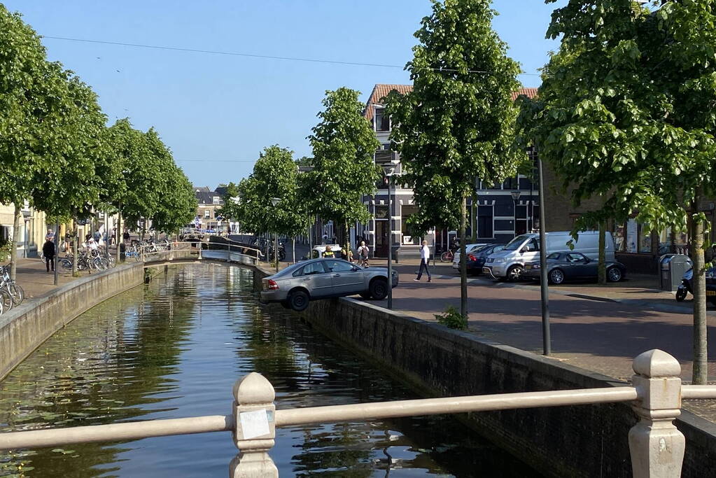 Auto blijft op randje van kade hangen boven gracht