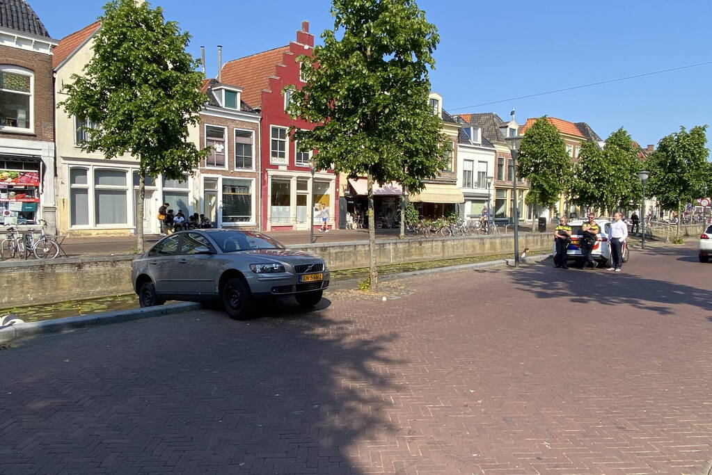 Auto blijft op randje van kade hangen boven gracht