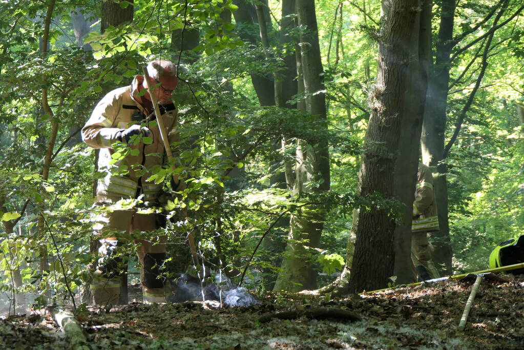 Brandweer blust smeulende delen in duingebied