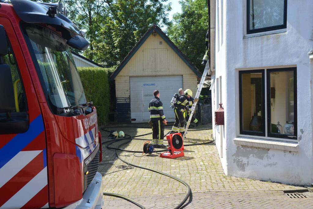 Brandweer blust dakbrand woning