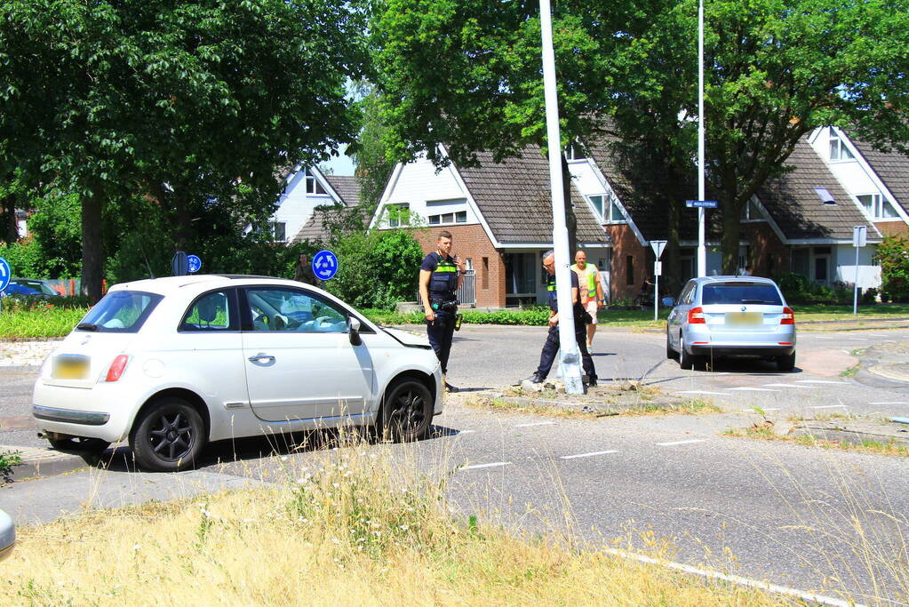 Automobilist ramt paal en lantaarnpaal bij rotonde