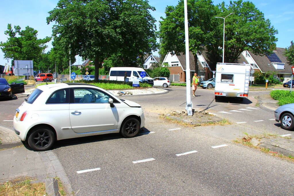 Automobilist ramt paal en lantaarnpaal bij rotonde