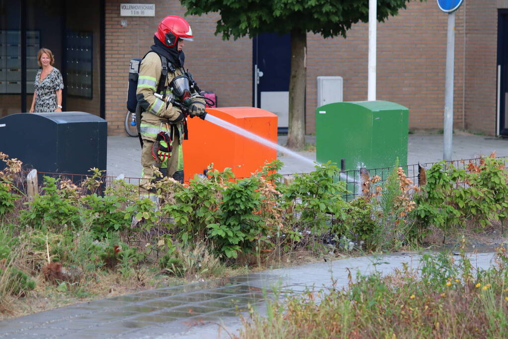 Gedumpt afval bij containers in brand