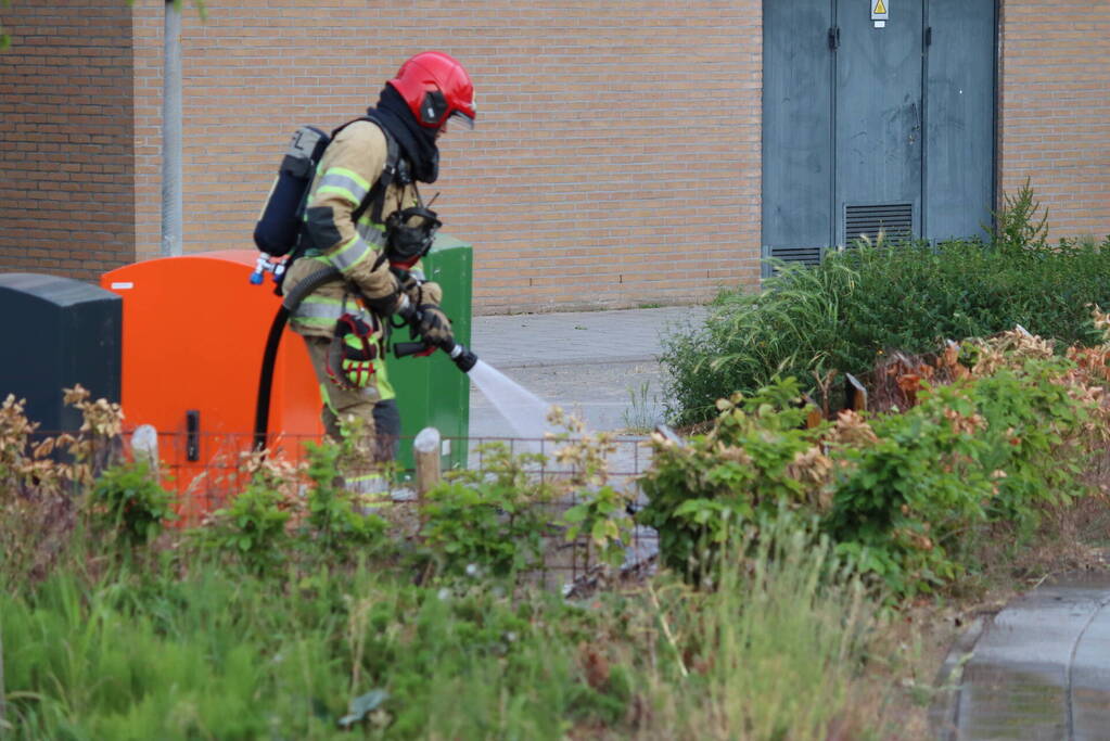 Gedumpt afval bij containers in brand