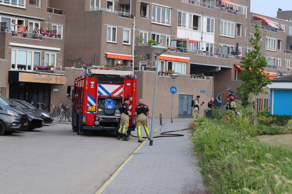 Gedumpt afval bij containers in brand