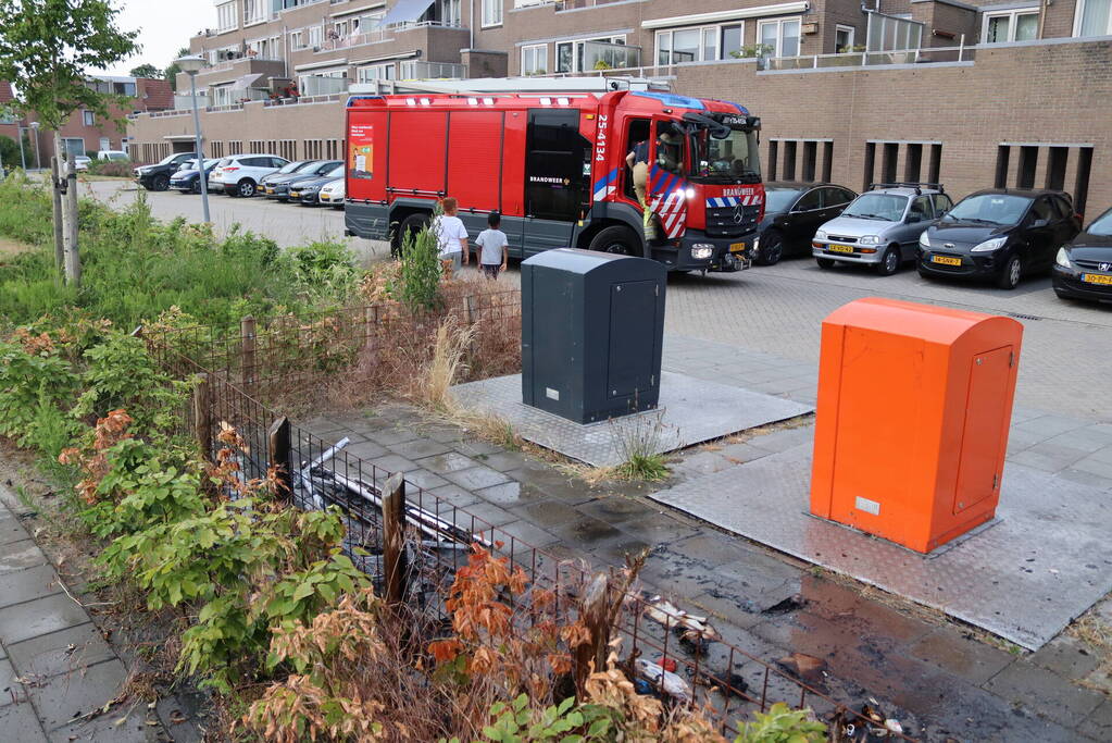 Gedumpt afval bij containers in brand