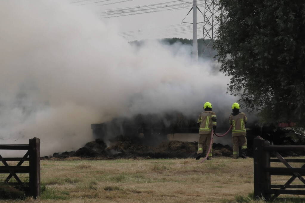 Trailer geladen met hooibalen uitgebrand in weiland