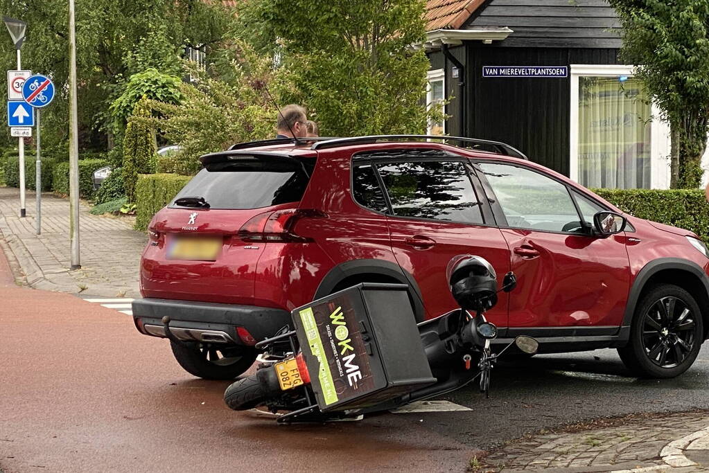 Automobilist en bezorger in botsing op kruising