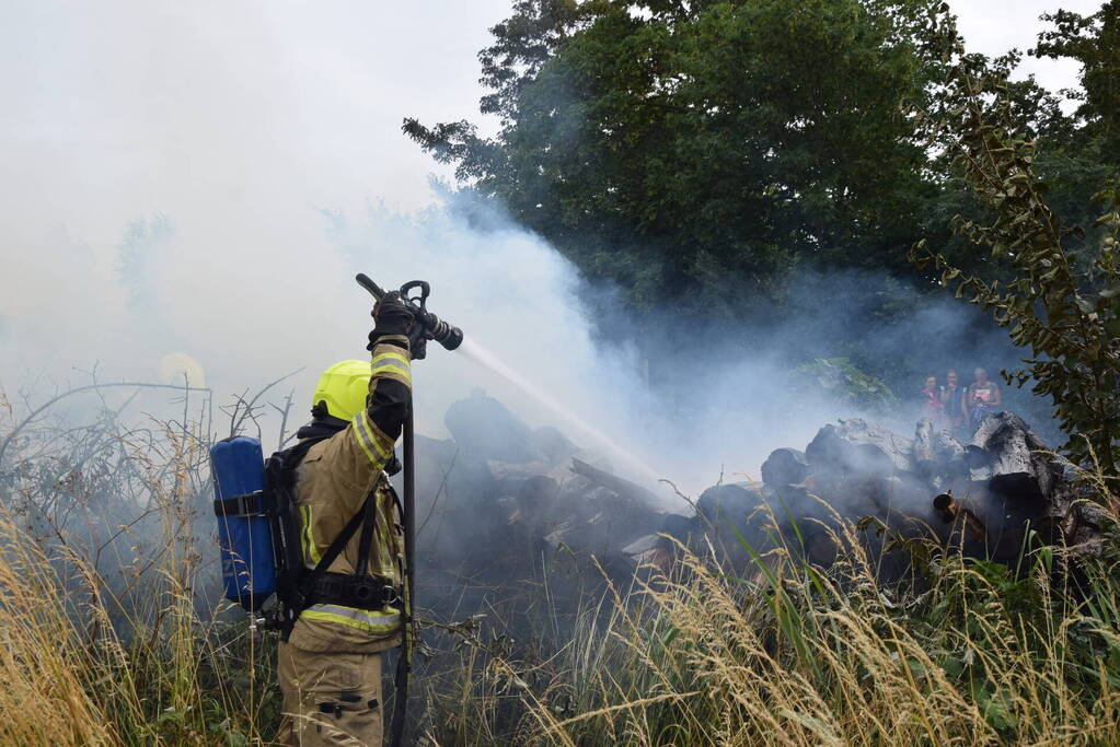 Hevige brand in stapel met houtblokken en snippers