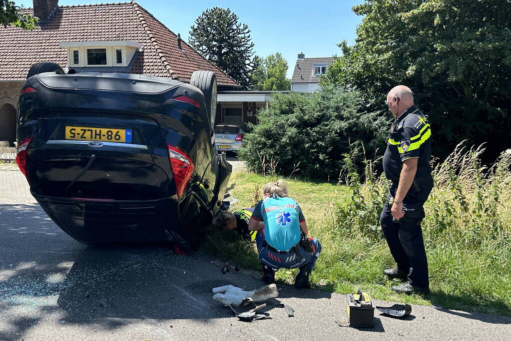 Auto belandt op de kop na botsing tegen boom