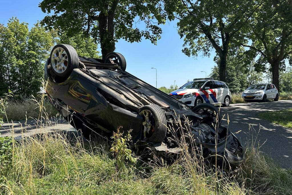 Auto belandt op de kop na botsing tegen boom