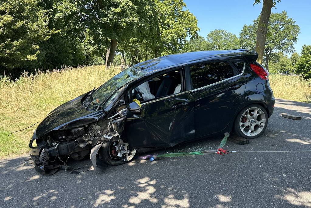 Auto belandt op de kop na botsing tegen boom